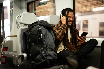 Young man listening the music while traveling by a train. Handsome young man traveling by a train.