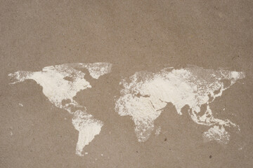 World map dusted on flour craft paper with copy space. World food safety concept.