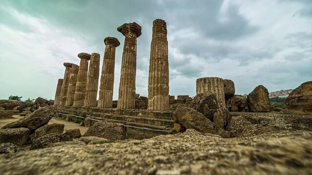 View of the pillars in Valle dei Templi near Agrigento in Sicily, Italy at daytime in timelapse. A cloudy morning over Greek ruins.