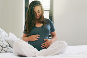 I have so much love for my unborn baby. Shot of a young pregnant woman relaxing at home.