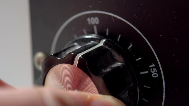 Power control of a retro old analog station with a dusty dial close-up. Hand turn close up. Macro shot