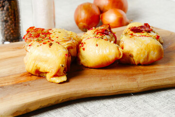 Rolled corn fed chicken thigs with herbs on a wooden board. Poultry product.