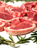 Fresh lamb chops and green rosemary herb on white background. Meat industry product. Butcher craft