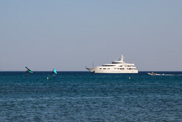 Luxury high-speed white boat and surfers in the Mediterranean sea in summer in Greece