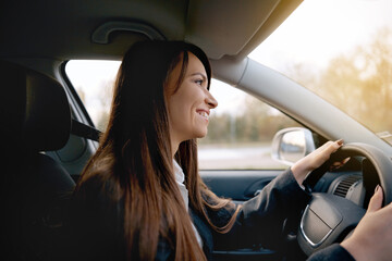 Naklejka na ściany i meble Beautiful young happy smiling woman driving her new car