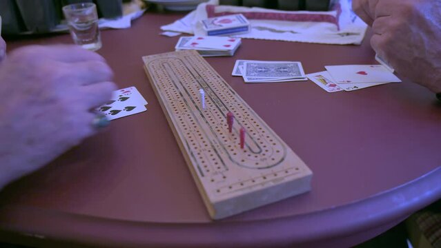 Two friends play cribbage, closeup. Active seniors concept.