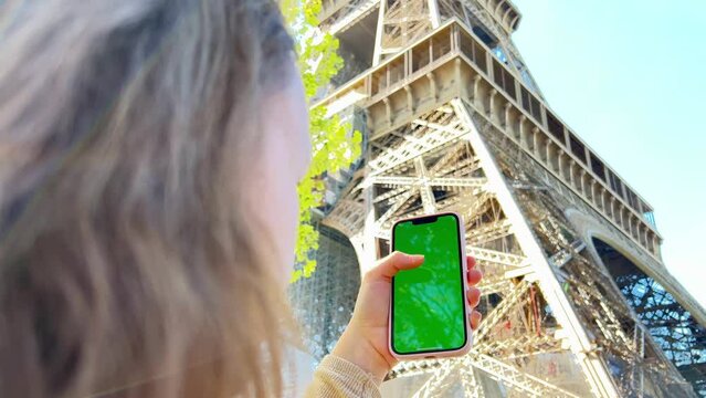 A woman's hand with vitiligo holds smartphone with green screen. Back view shot. Chroma key, close up woman hand holding phone with vertical green screen. High quality 4k footage
