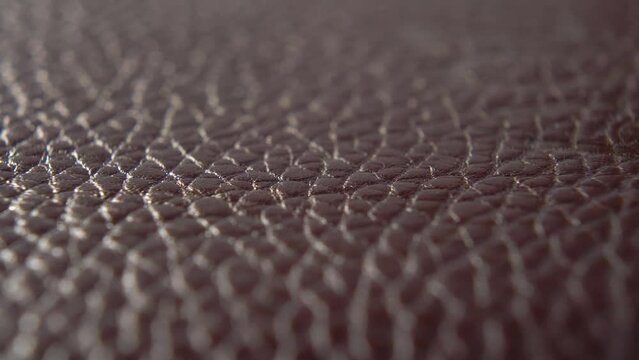 Rough cowhide covering close-up. Texture of brown shabby material. Macro. Dolly shot