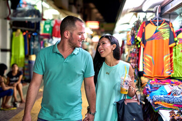 Fototapeta premium Are you having fun. Shot of a happy couple walking hand in hand.