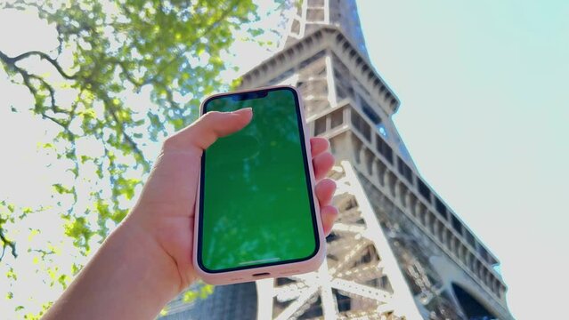 A woman's hand with vitiligo holds smartphone with green screen. Back view shot. Chroma key, close up woman hand holding phone with vertical green screen. High quality 4k footage