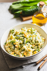 Healthy salad of green wild leek, poached egg and cucumber, close up. Wild garlic salad with boiled eggs
