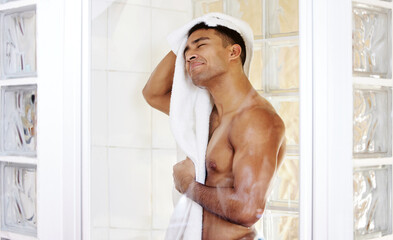 Fototapeta na wymiar Theres nothing a good shower cant fix. Shot of a man drying himself after taking a shower.