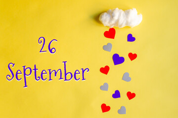 26 september day of month, colorful hearts rain from a white cotton cloud on a yellow background. Valentine's day, love and wedding concept