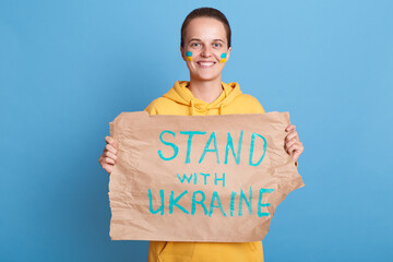 Image of smiling positive woman on protest against Russia invasion of Ukraine, holding placard with...
