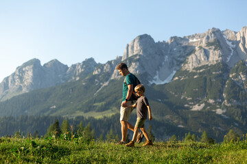 Family time in mountains. Father and son hiking in the Austrian Alps