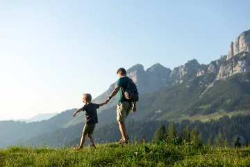 Familienzeit in den Bergen. Vater und Sohn wandern in den österreichischen Alpen © Olha Sydorenko