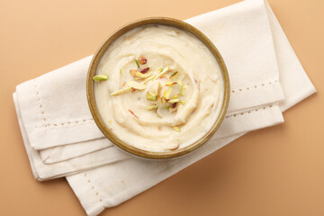 Shrikhand is an Indian sweet dish made of strained curd,garnished with dry fruits and saffron. Served in a ceramic bowl.Selective focus