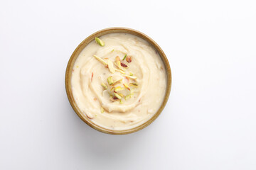 Shrikhand is an Indian sweet dish made of strained curd,garnished with dry fruits and saffron. Served in a ceramic bowl.Selective focus