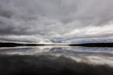Dramatic autumn clouds reflection in Muonio lake, Lapland, Northern Finland
