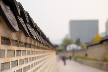 Fototapeta premium Soft blur focus korean palace stone wall of korean traditional village house,blured traveller sightseeing in Korea fence in South Korea.