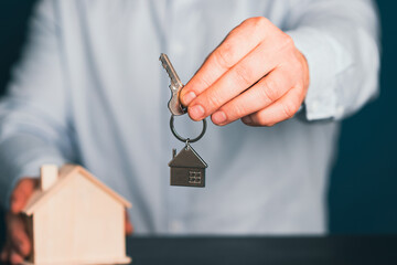Hands with little house and key. Real estate and construction concept.