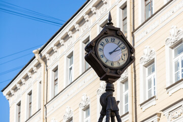 Fototapeta na wymiar Old street clock on the background of the building