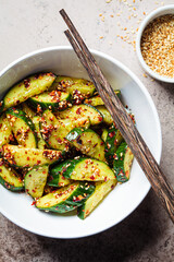 Chinese smashed cucumber salad with chili peppers and sesame seeds.