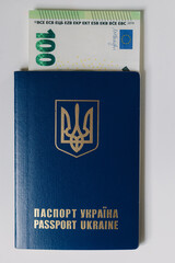 Hundred euro banknote inside Ukrainian passport. Bribe during the war