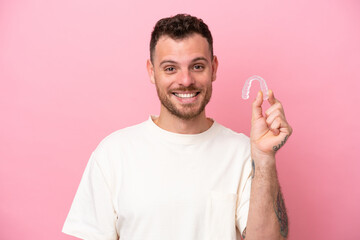 Brazilian man holding invisible braces with happy expression