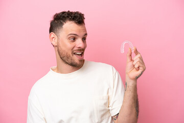 Brazilian man holding invisible braces with happy expression