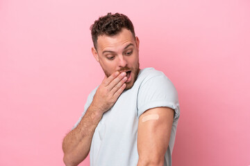 Young Brazilian man wearing a band-aids isolated on pink background with surprise and shocked facial expression