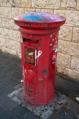 a typical red british mailbox on the street.