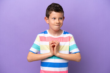 Little boy isolated on purple background scheming something