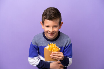 Little boy holding fried chips isolated on purple background smiling a lot