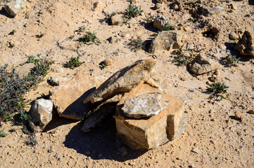 stacked together stones of different sizes and shapes in the desert.