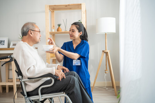 Asian physician nurse support to elderly male patient on wheelchair. 