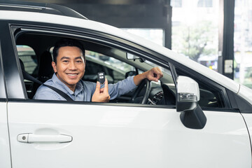 Fototapeta na wymiar Asian attractive man customer hold remote car key while sit in vehicle
