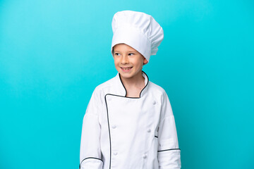 Little chef boy isolated on blue background looking side
