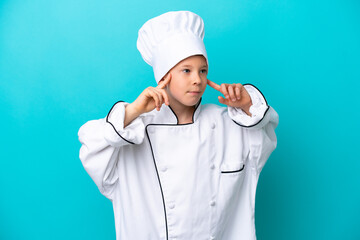 Little chef boy isolated on blue background having doubts and thinking