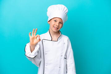 Little chef boy isolated on blue background showing ok sign with fingers
