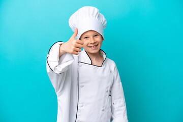Little chef boy isolated on blue background with thumbs up because something good has happened
