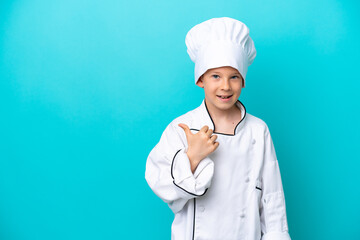 Little chef boy isolated on blue background pointing to the side to present a product