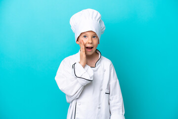 Little chef boy isolated on blue background with surprise and shocked facial expression