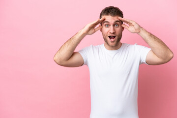 Fototapeta na wymiar Young caucasian man isolated on pink background with surprise expression