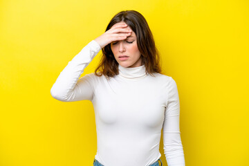 Young caucasian woman isolated on yellow background with headache