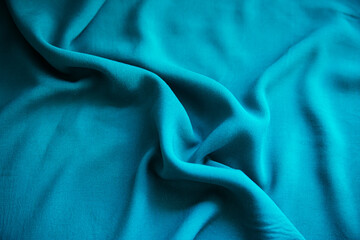 Obraz premium Blue wrinkled fabric lies in folds on the table with drapery.