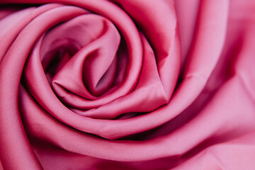 Fototapeta na wymiar A pink wrinkled fabric lies in folds on a draped table.