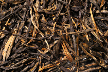 Dian Hong Jin Zhen. Red tea, golden needles on white background. Top view. Close up. High resolution