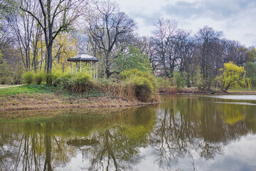 Fototapeta na wymiar Teich im Park Palmengarten mit Pavillion im Hintergrund, in Leipzig, Sachsen 