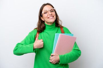 Young student caucasian woman isolated on white background with thumbs up because something good has happened